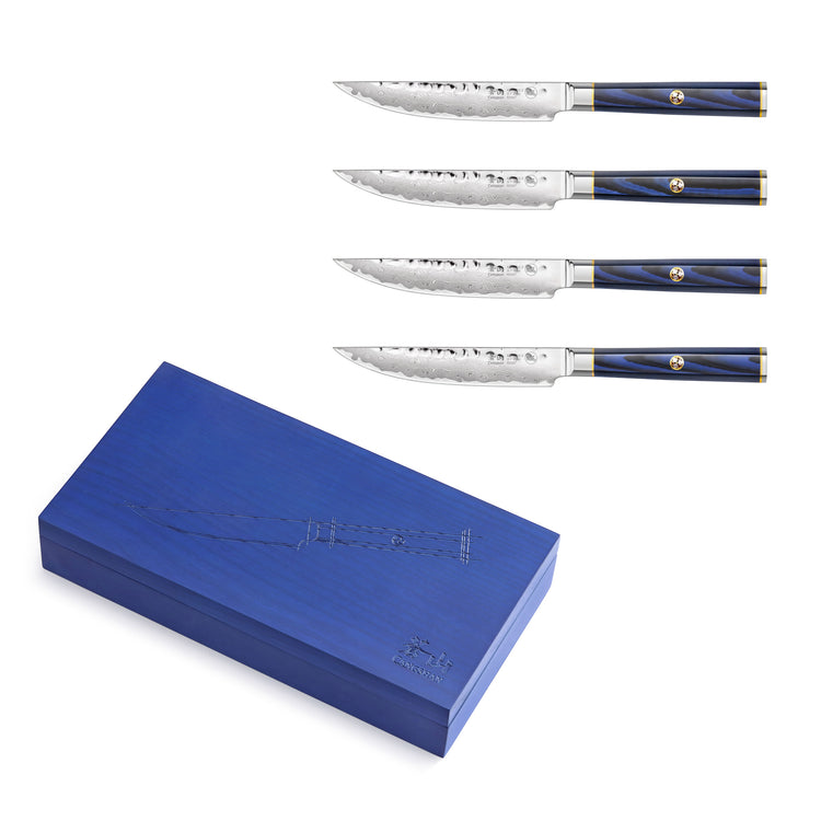 Four steak knives with patterned blades and blue handles, displayed above a closed blue wooden storage box.