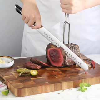 
                    
                      Person slicing medium-rare roast beef on wooden cutting board using a long black-handled knife and meat fork.
                    
                  