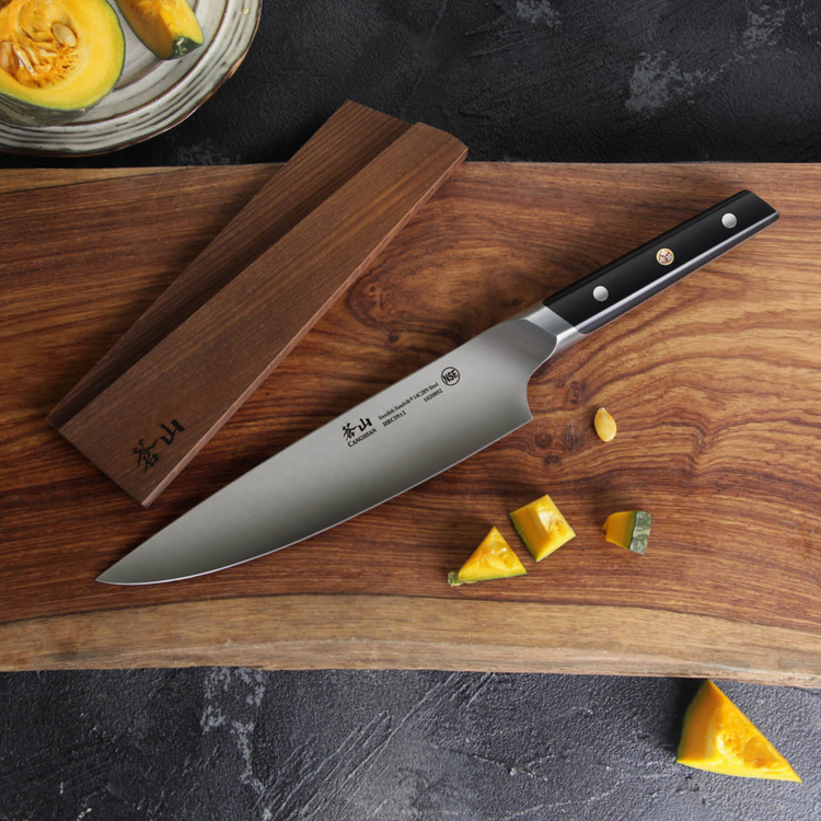 8-inch chef knife with black handle and wooden sheath on a wooden cutting board with cut pumpkin pieces.