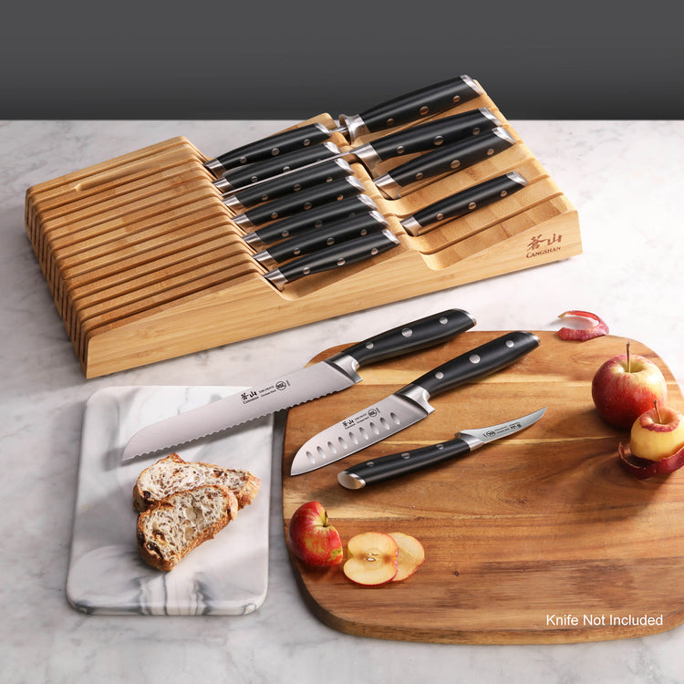 Bamboo knife organizer with 15 slots holding knives, next to cutting boards with sliced apples and bread.