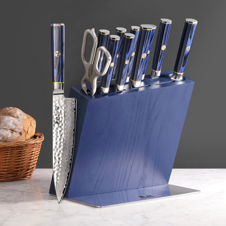 Blue knife block set with seven knives and kitchen shears, featuring hammered blades and polished handles.