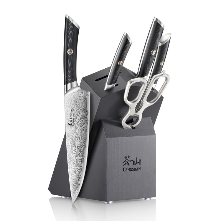 Six-piece knife set with patterned blades, black handles, scissors, and a black angled block with "CANGSHAN" logo.