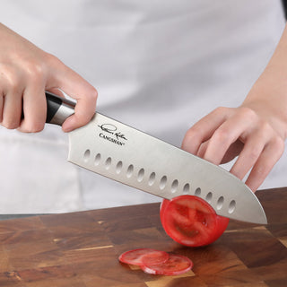 
                    
                      Hand holding a Santoku knife slicing a tomato on a wooden cutting board.
                    
                  