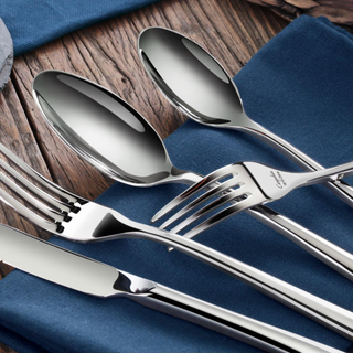 
                    
                      Five pieces of polished stainless steel flatware, including two spoons, two forks, and one knife, arranged on a blue cloth.
                    
                  
