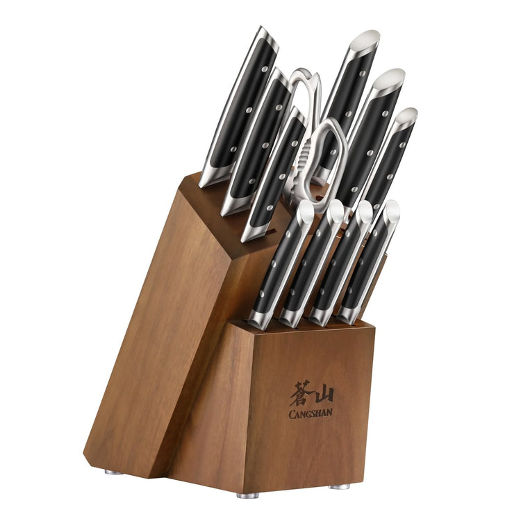 Wooden knife block holding eight knives and kitchen shears with black handles and silver rivets.