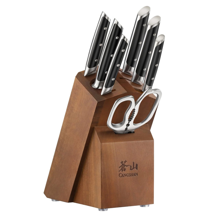 Wooden knife block holding six knives with black handles and a pair of kitchen scissors.