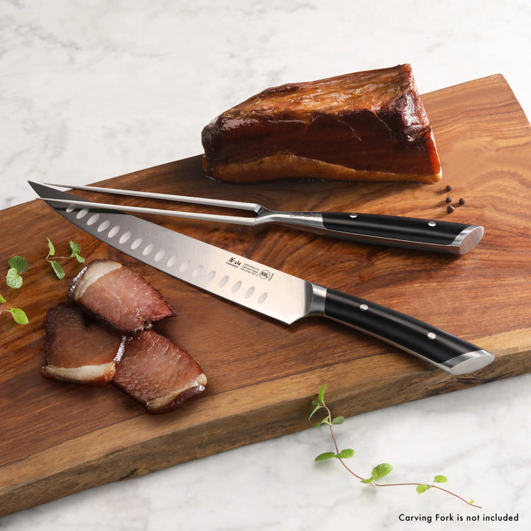 9-inch carving knife with black handle and hollow edge, next to sliced meat on wooden cutting board