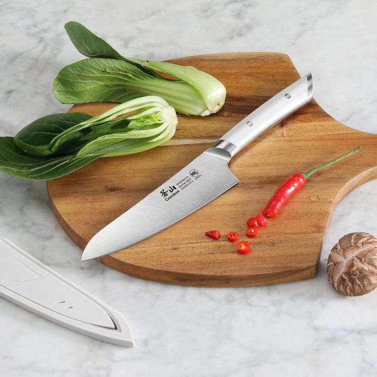 5.5-inch utility knife with stainless steel handle on a wooden cutting board with bok choy, chili pepper, and mushroom.
