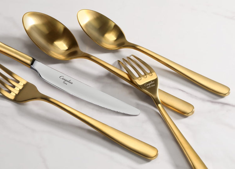RAIN II Series matte gold flatware set featuring spoons, forks, and a knife on a white marble surface.