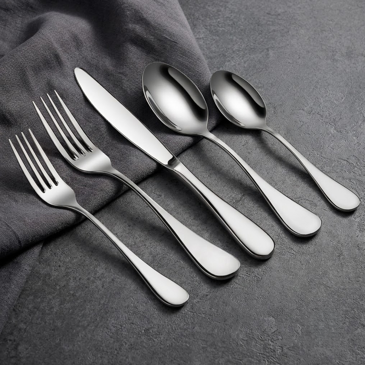Five-piece polished silver flatware set featuring two forks, a knife, and two spoons on a dark surface.