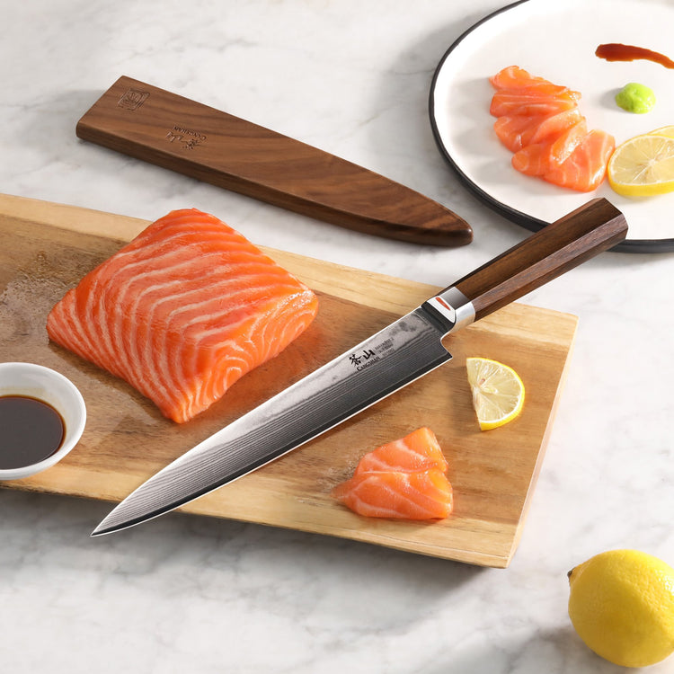 MAYA Series 8-inch sashimi knife with a Damascus steel blade and wooden sheath, resting on a board next to raw salmon.