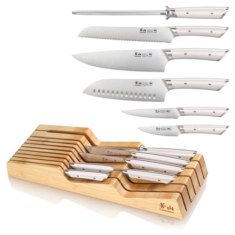Seven-piece knife set with white handles, including sharpening steel, bread knife, chef's knife, santoku, paring knives, and