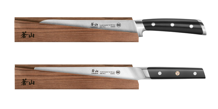 Two kitchen knives with black handles resting on solid ash wood magnetic sheaths with Japanese characters.