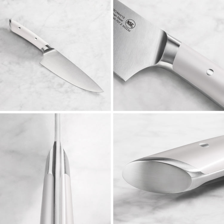 Chef knife with a white handle, showing full blade, handle details, and tang construction on a marble surface.