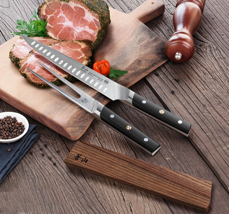 Two black-handled carving knife and fork resting on wooden cutting boards with sliced seasoned meat, pepper grinder, and pepp