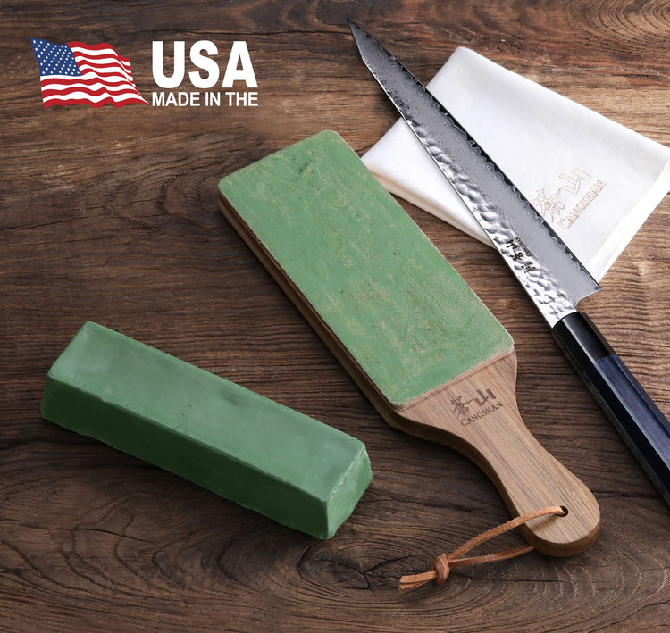 Green honing polish compound bar and paddle with wooden handle next to a serrated knife and white cloth on a wooden surface.
