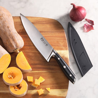 
                    
                      8-inch chef knife with black handle and sheath on wooden cutting board with sliced squash and red onion.
                    
                  