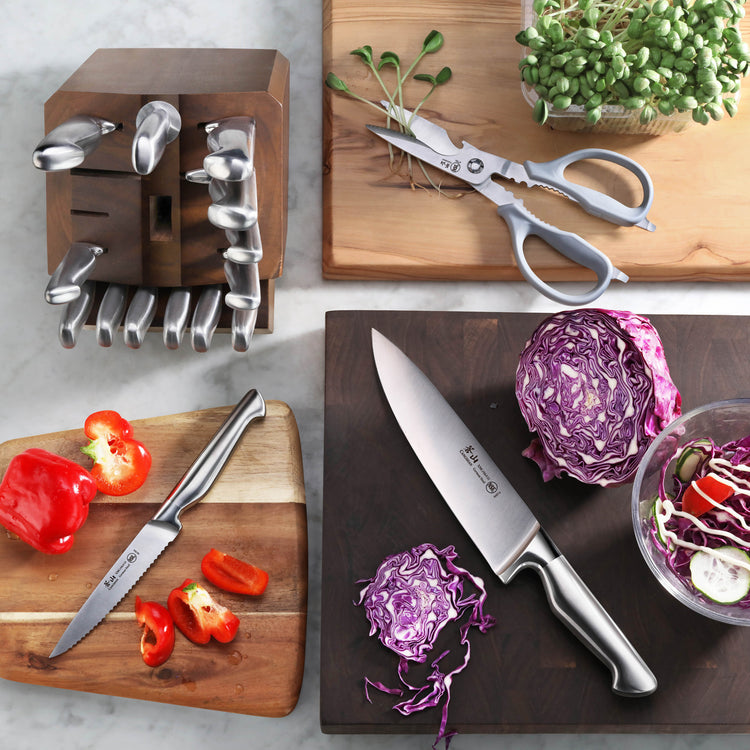 Knife block set with various knives, kitchen shears, and cut vegetables on wooden cutting boards.
