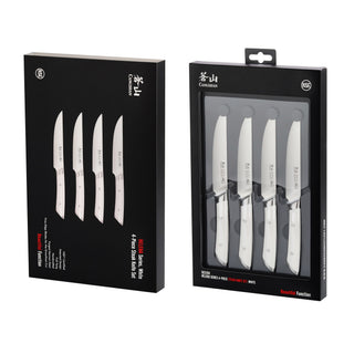 
                    
                      Four white-handled steak knives displayed in black retail packaging with clear front panel.
                    
                  