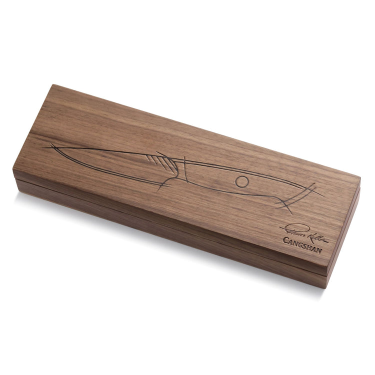 Rectangular wooden box with a knife sketch and signature on the lid, closed and resting on a white surface.