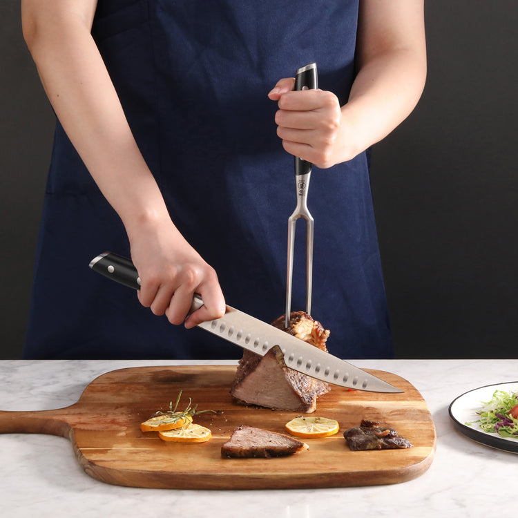 Person carving cooked meat on wooden cutting board using black-handled carving knife and fork.