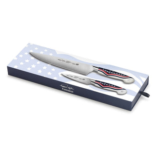 
                    
                      Two forged steel knives with American flag design handles displayed on a blue and white star-patterned box.
                    
                  