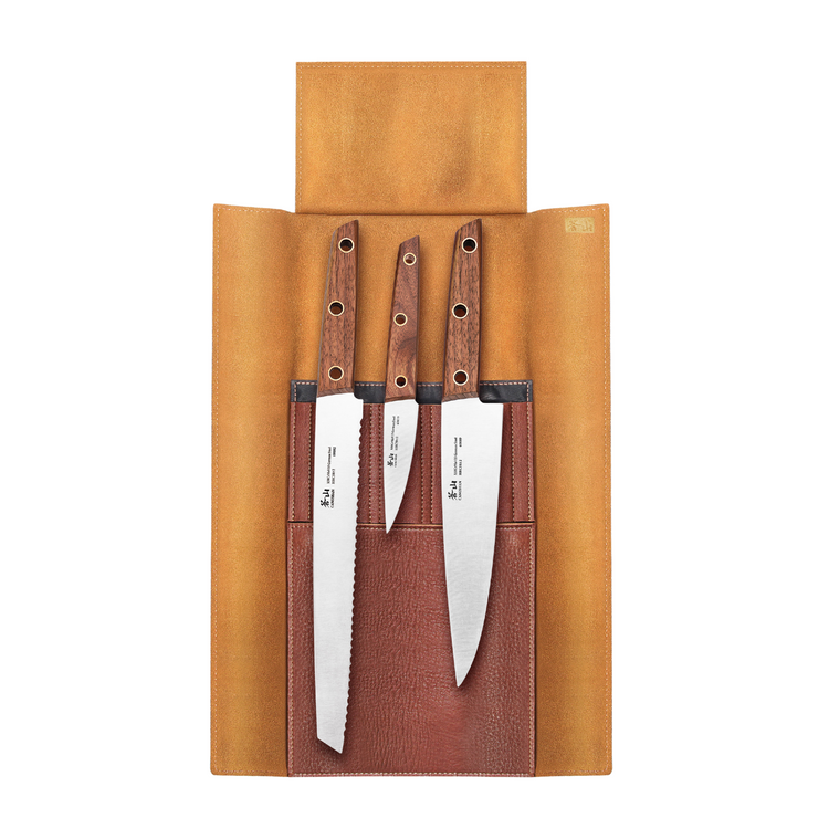 Three knives with wooden handles in a tan leather roll-up case with stitched pockets.