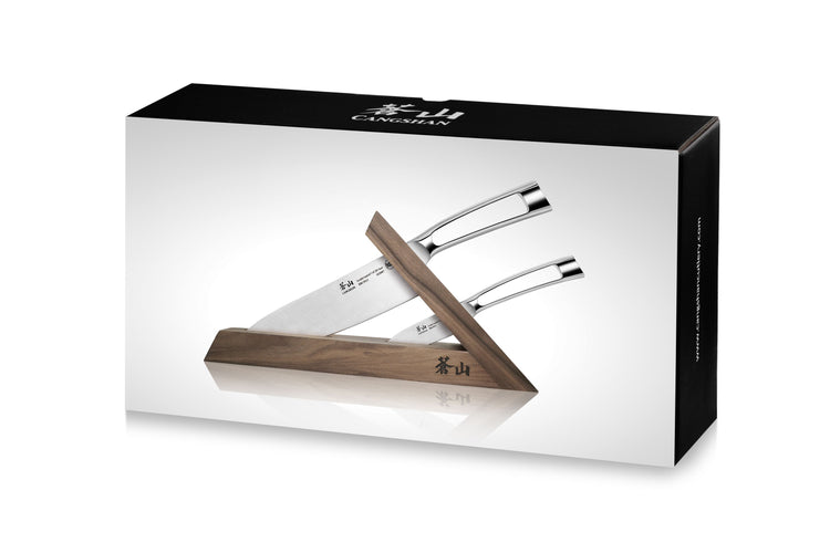 Three kitchen knives with stainless steel handles in a walnut wooden block angled for display.